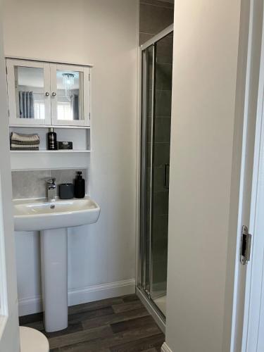 a bathroom with a sink and a shower at Sheffield Boutique Cosy 3-bed Home in Sheffield