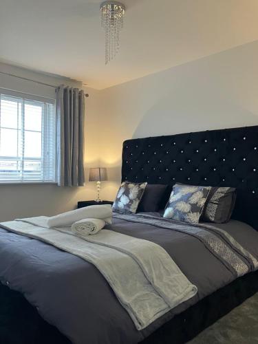 a bedroom with a large bed with a black headboard at Sheffield Boutique Cosy 3-bed Home in Sheffield