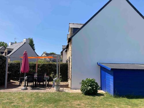 a house with a blue door and a table and chairs at Maison entre plage et port in Sarzeau