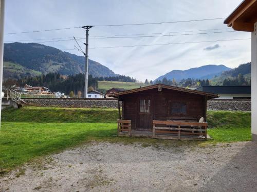 a small wooden building with a bench in a field at Zettler Apartment in Großsölk