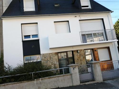 une maison blanche avec un toit noir dans l'établissement Colette chambre chez l'habitant, à Carhaix-Plouguer