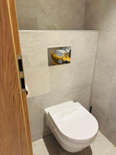 a bathroom with a white toilet and a yellow object at Apartments Relax Tále in Evergreen Resort in Tale