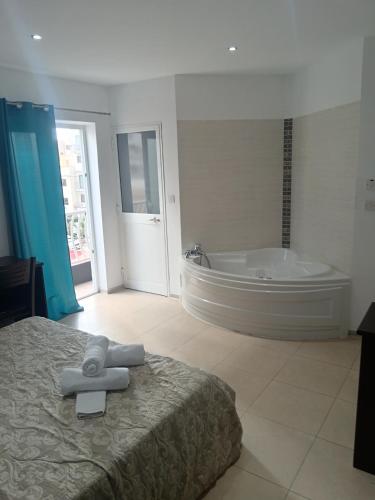 a bedroom with a large tub and a bed and a bath tub at Magnolia Guest House in St. Julianʼs