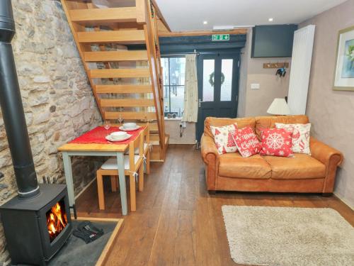 a living room with a couch and a wood stove at Stable Cottage in Pembroke