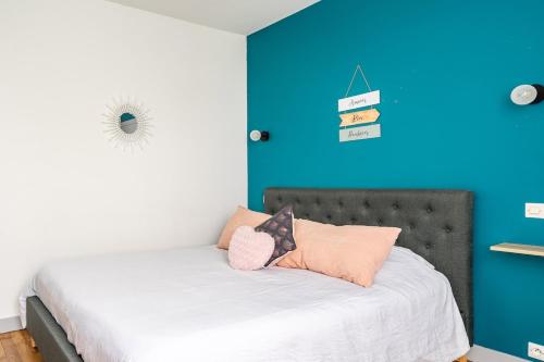 a bedroom with a bed with a blue wall at Le gite d 'Amélie maison rénovée 6 couchages 2 salles de bains in Célon