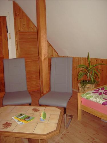 a room with two chairs and a table and a bed at Zweibettzimmer "Marie" in Tribsees