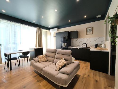 a living room with a couch and a kitchen at Le Léon - Hypercentre in Auch