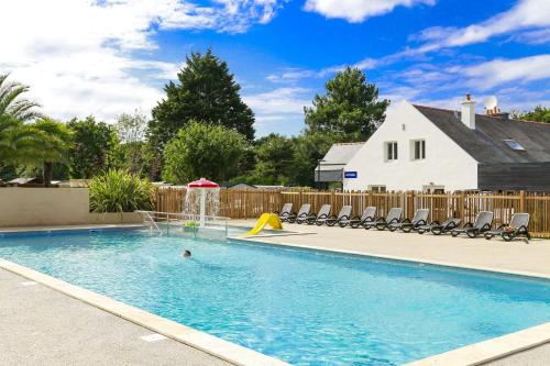 une personne se baignant dans une piscine avec une fontaine dans l'établissement Domaine Résidentiel de Plein Air Le Vieux Moulin, à Erquy