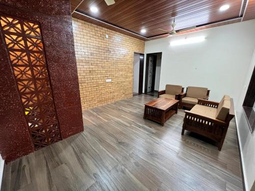 a living room with chairs and a table in a room at Shree Balaji Natures lap villa in Mirya