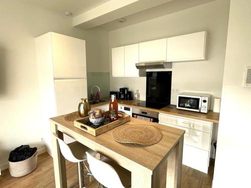 - une cuisine avec une table en bois et un comptoir dans l'établissement Le Clemenceau - centre ville, proche gare et commerces, à Saint-Brieuc