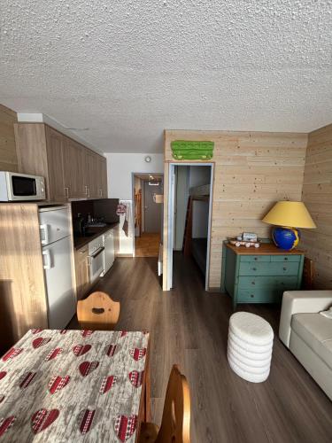 une cuisine et un salon avec une table et un canapé dans l'établissement Bel Appart Résidence Gentianes Monitor, à Aragnouet