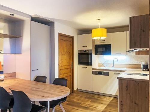 une cuisine et une salle à manger avec une table et des chaises en bois dans l'établissement Apartment L'Espace Montagne-11 by Interhome, à Chamonix-Mont-Blanc