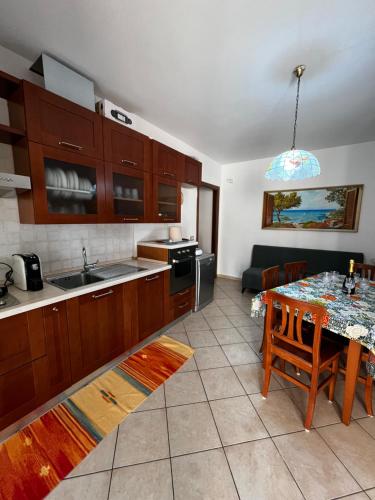 a kitchen with a table and a dining room at La casa di Flora Appartamento ad Alghero in Alghero