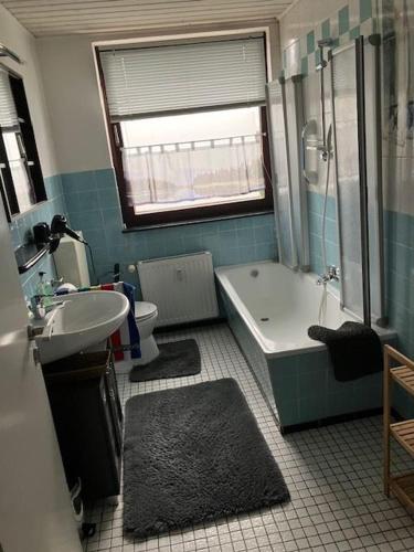 a bathroom with a tub and a sink and a toilet at LeaID in Idstedt