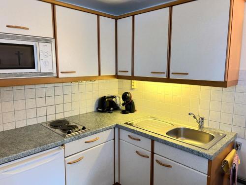 a kitchen with a sink and a microwave at Holiday Home Wallner by Interhome in Fusch an der Glocknerstraße
