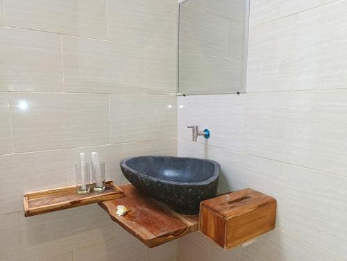 a bathroom with a black sink on a wooden table at Green Sunrise Hill View in Nusa Penida