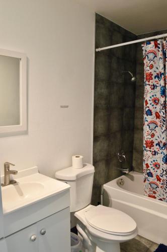 a bathroom with a toilet sink and a shower curtain at Modern 1-Bedroom Condo in Las Vegas