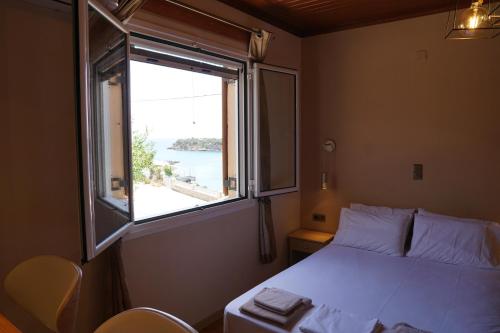 um quarto com uma cama e uma janela grande em (305)Sea And Sun apartments em Kardamili
