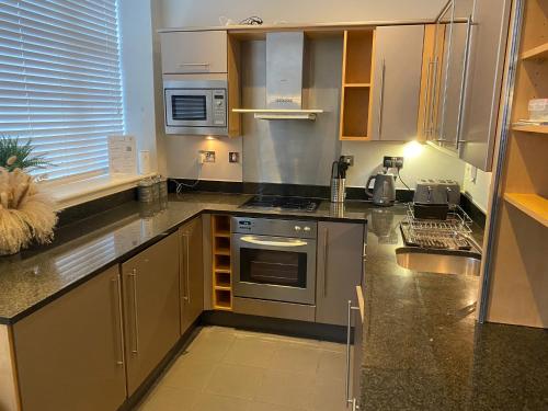 a kitchen with a stove and a sink at Your Holiday & Home Brighton in Brighton & Hove