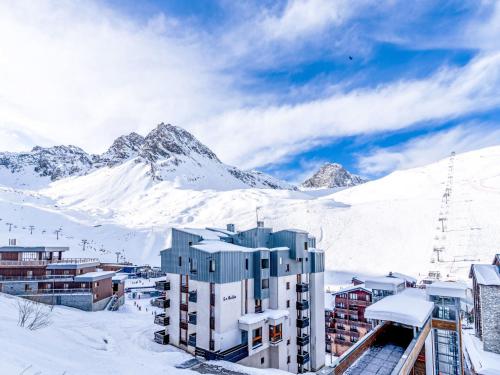 un bâtiment dans la neige avec une montagne en arrière-plan dans l'établissement Studio Plein Soleil - Val Claret-9 by Interhome, à Tignes
