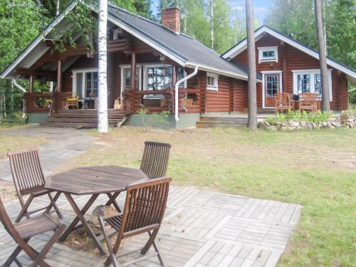 een tafel en stoelen voor een blokhut bij Holiday Home Honkaranta by Interhome in Karstula