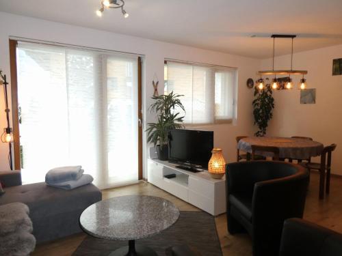 un soggiorno con un divano e un tavolo di Apartment Chalet La Muntaniala by Interhome a Grindelwald