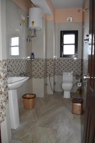a bathroom with a sink and a toilet in it at RKM Biulding Sharma B&B in Shimla
