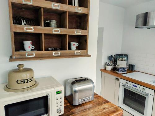 a kitchen with a microwave and a toaster oven at Sett Cottage, Hayfield in Hayfield