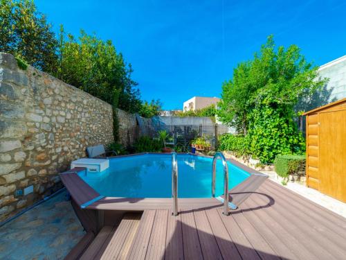 einen Pool auf einer Holzterrasse neben einer Wand in der Unterkunft Holiday Home Can Canto by Interhome in Binissalem