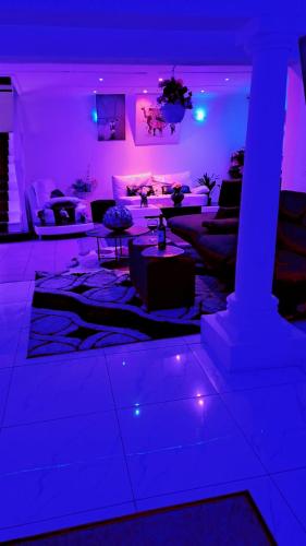 a living room with purple lights and a couch at Sunset Roof in Margate
