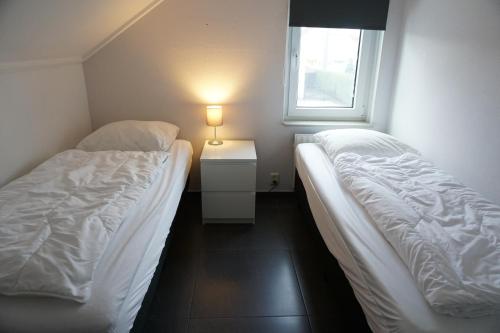 ブレスケンスにあるKustverhuur, Vakantiepark Fort Soleil 36の窓のある小さな部屋にベッドが2つある