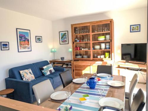 un salon avec une table et un canapé bleu dans l'établissement Apartment Les Mas de la Mer-4 by Interhome, à Saint-Aygulf