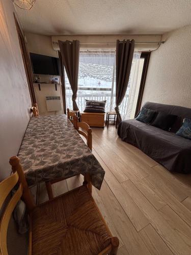 - une chambre avec une table, un lit et une fenêtre dans l'établissement T2 residence Grand Schuss cote pistes, à Saint-Lary-Soulan