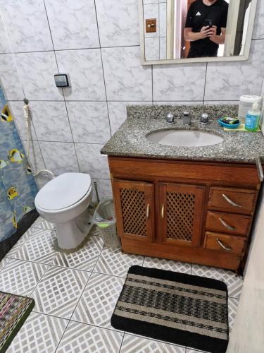 Un baño con lavabo, inodoro y espejo. en Ap simple e bem localizado no centro da lapa, en Río de Janeiro