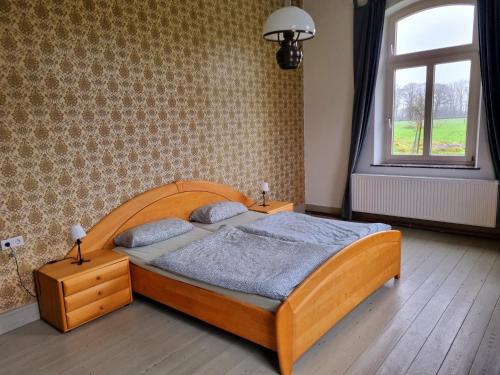 a bedroom with a wooden bed and a window at Gartenblick im Gutshaus - Ferienwohnung in Kevelaer