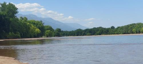a river with trees and mountains in the background at La casa de Los Patitos in Arroyo de Los Patos