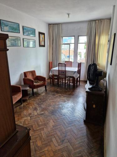 una sala de estar con un sofá, una mesa y sillas en Ap simple e bem localizado no centro da lapa, en Río de Janeiro