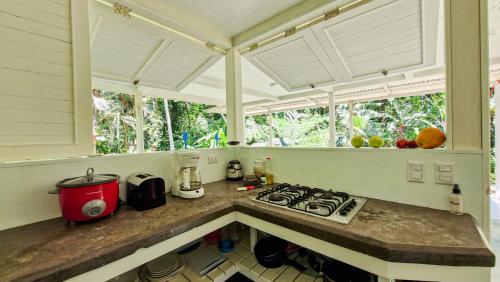 a kitchen with a stove and some windows at Jungle Dreamz in Manzanillo