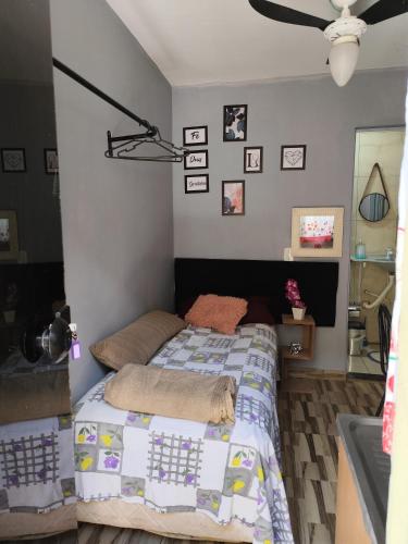a bedroom with a bed with a quilt on it at Família Durães Kitnets02 in Londrina
