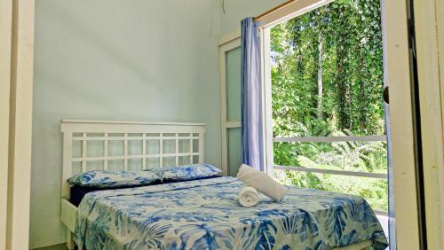 a bedroom with a bed and a large window at Jungle Dreamz in Manzanillo