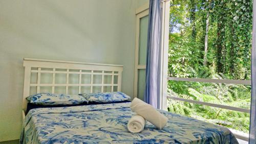 a bed with a stuffed animal on it in front of a window at Jungle Dreamz in Manzanillo