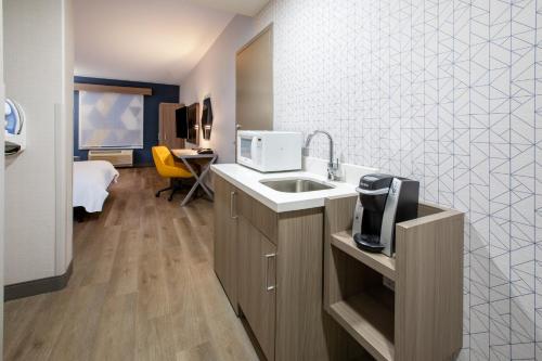 a kitchen with a sink and a microwave at Holiday Inn Express & Suites Lathrop by IHG in Lathrop
