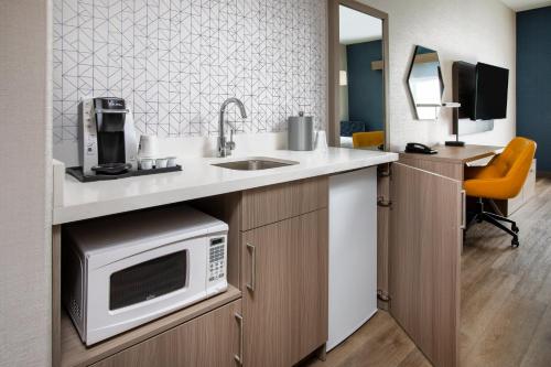 a kitchen with a sink and a microwave at Holiday Inn Express & Suites Lathrop by IHG in Lathrop