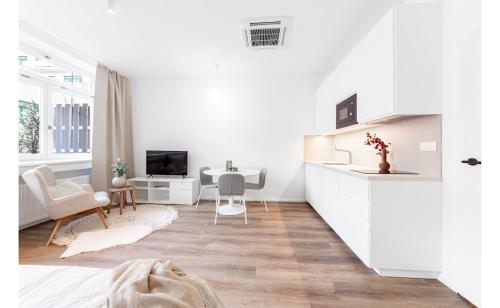 a white apartment with a kitchen and a living room at Zorya Sunrise Apartment in Brno