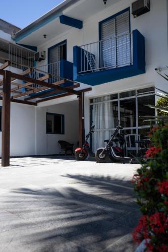 two scooters parked in front of a building at MOVA - Hotel Costa Azul in Ubatuba