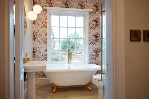 a bathroom with a tub and a sink and a window at The Manor Lodge, Repton in Repton