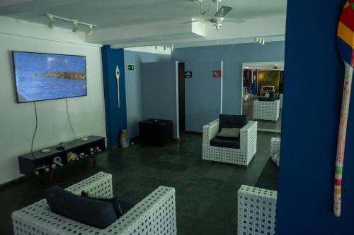 a living room with chairs and a painting on the wall at MOVA - Hotel Costa Azul in Ubatuba