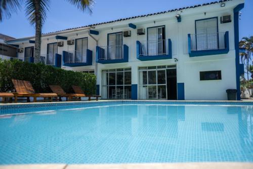 a swimming pool in front of a building at MOVA - Hotel Costa Azul in Ubatuba