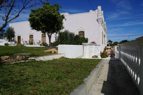 a white house with a fence and a yard at Casa de Marim AL in Olhão