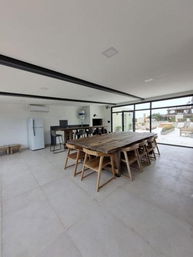 a large room with a large wooden table and chairs at Alquiler De Departamento Monoambiente Con Terraza, Frente Al Mar En La Costa Quequén, Con Pileta, Solarium y Sum Con Parrilla in Quequén